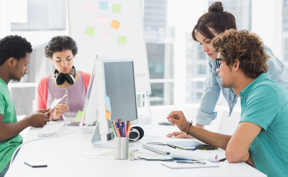 Group of workers from a small business assessing reports from their ERP solution.