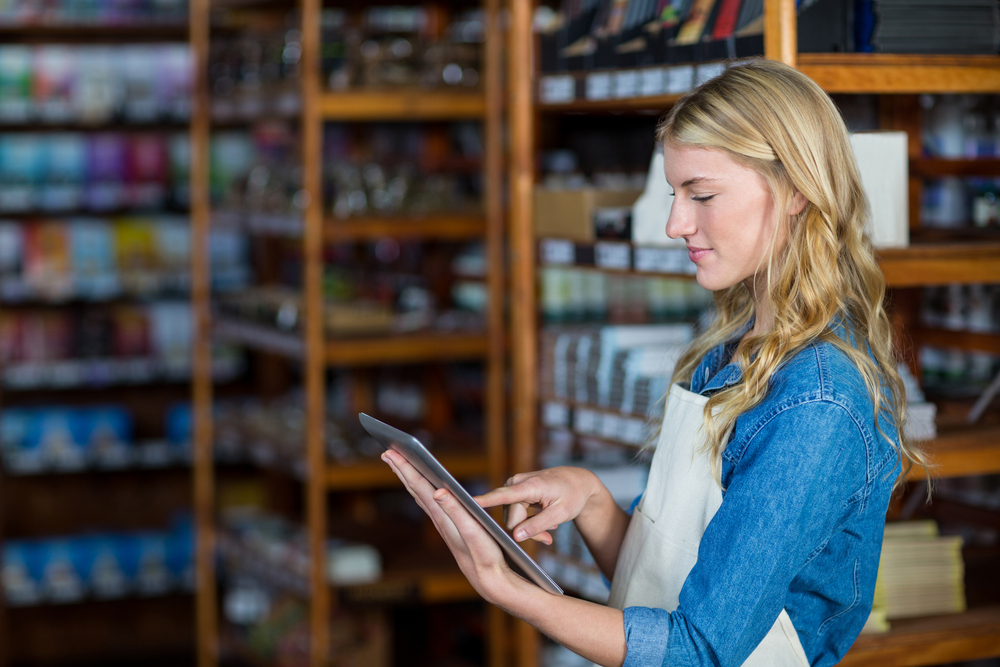 Smiling female staff using digital tablet in supermarket-1
